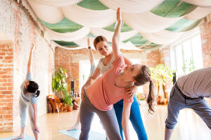 group of people doing yoga exercises at studio